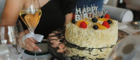 A birthday cake with 'Happy Birthday' candles on a marble table.