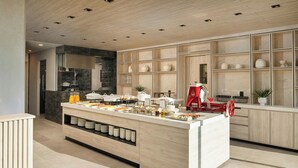 A modern kitchen with a central island, built-in shelves, and a coffee machine. - AC Hotel By Marriott San Luis Potosi (San Luis Potosi)