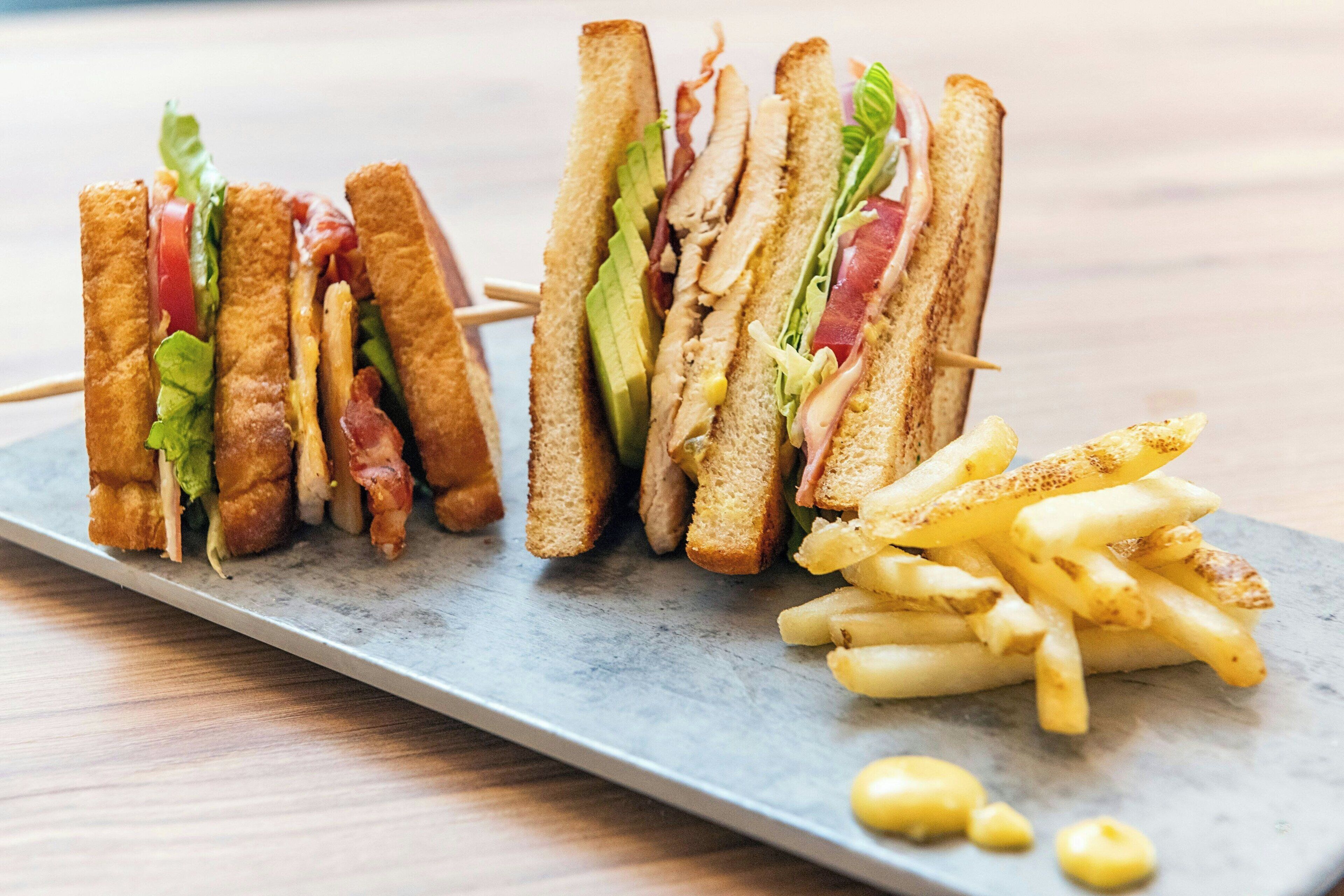 A plate with two sandwiches and a side of French fries.