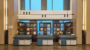 A lobby with a reception desk, wooden paneling, and a large window. - Four Points By Sheraton Shenzhen Bay (Shenzhen)