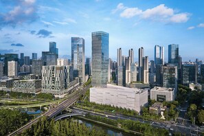 Paesaggio urbano moderno con grattacieli, un fiume e un ponte.