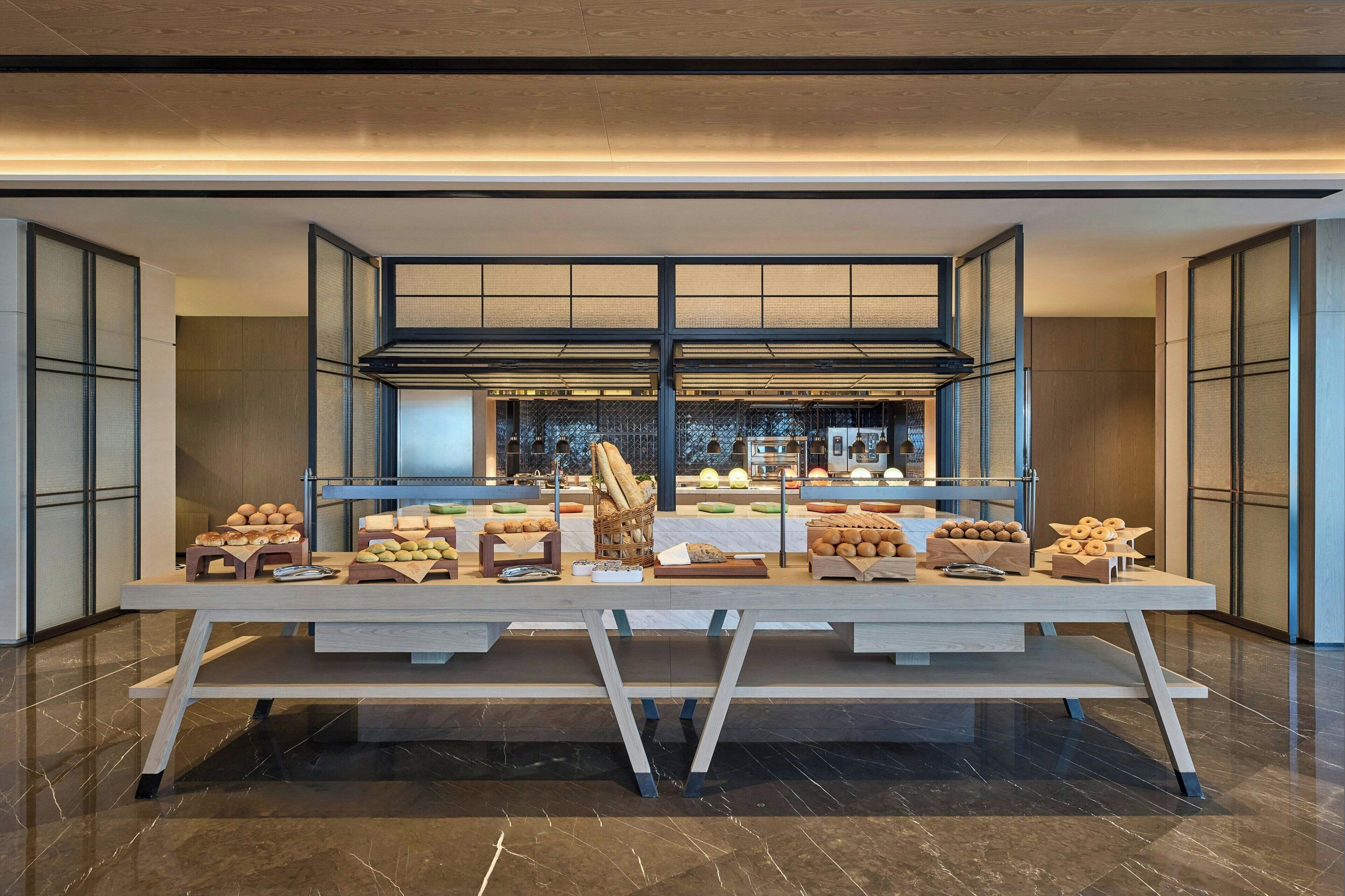 A buffet setup with various food items and a modern interior design.