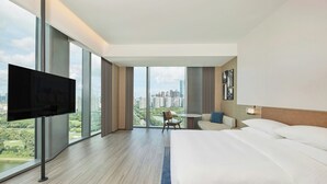 A hotel room with a large bed, a TV, a desk, and a view of a cityscape. - Four Points By Sheraton Shenzhen Bay (Shenzhen)