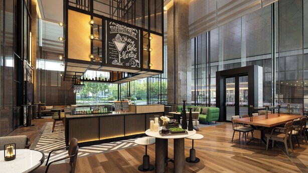 A modern hotel lobby with a bar area, seating arrangements, and large windows offering views of the outdoors. - Four Points By Sheraton Wuhan Hankou (Wuhan)
