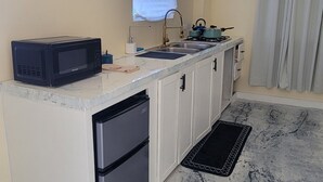 A compact kitchen with a microwave, stove, sink, and refrigerator. - Beautiful apartment with AC in Saint George's (Saint George's)