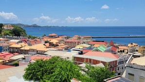 A coastal town with colorful buildings, a clear blue sky, and boats in the water. - Beautiful apartment with AC in Saint George's (Saint George's)