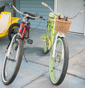 Deux vélos sont garés sur une surface en béton, l’un d’eux est équipé d’un panier à l’avant.