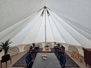 A tent with a table and chairs, a plant, and a board game. - Glamping in the trees (Talkeetna)