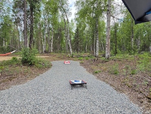 A gravel path in a forested area with a table and a red and white sign.