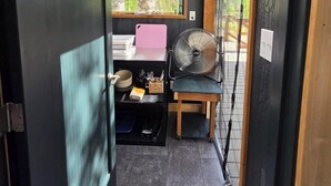 Et kompakt køkken med et vindue, en ventilator og et lille spiseområde.
