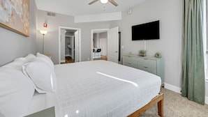 A bedroom with a bed, a ceiling fan, a TV, a dresser, and a door leading to another room. - Central Relaxing 1br Phoenix Retreat Near Airport 1 Bedroom Apts (Phoenix)