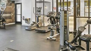 A modern gym with various exercise equipment, including treadmills and weight machines. - Central Relaxing 1br Phoenix Retreat Near Airport 1 Bedroom Apts (Phoenix)