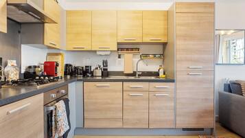 A modern kitchen with wooden cabinets, a built-in oven, and a stainless steel range hood.