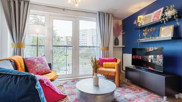 A modern living room with a sofa, coffee table, and TV.