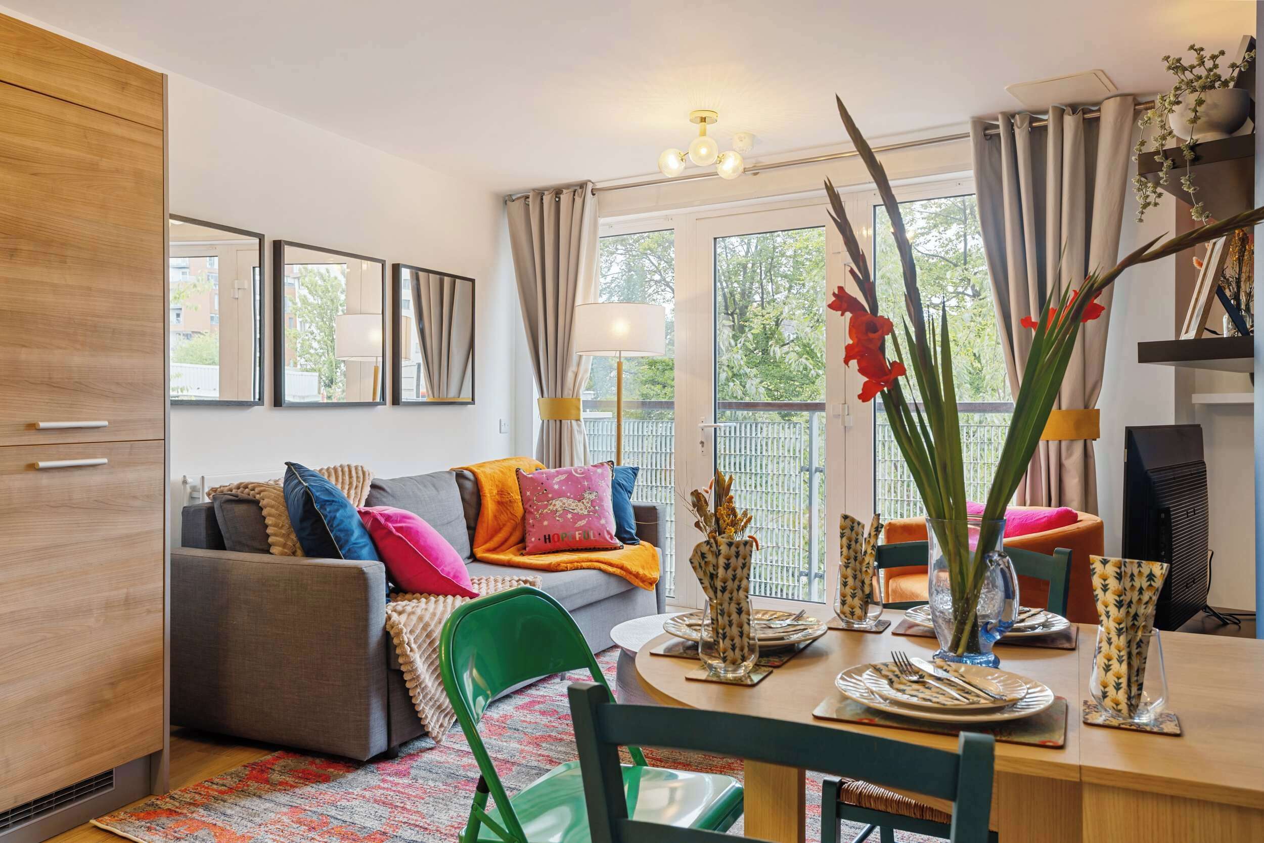 Een moderne woonkamer met een bank, eettafel, stoelen en een televisie.