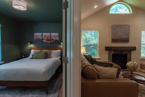 Een slaapkamer met een bed, nachtkastje en een wandlamp.