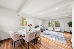 A spacious living area with a dining table, chairs, and a sofa. - Cozy Forest Hideaway in Incline Village Private Balcony Sierra Solace by Avantstay (Incline Village)