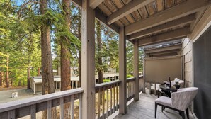 Ein überdachter Außenbereich mit Holzterrasse, einem Stuhl und einem Tisch.
