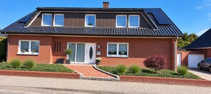 A two-story house with a brick facade, a front entrance, and a driveway. - "Cozy 'Agnes' Vacation Rental—Dog-Friendly & Comfortable" (Neuenkirchen)