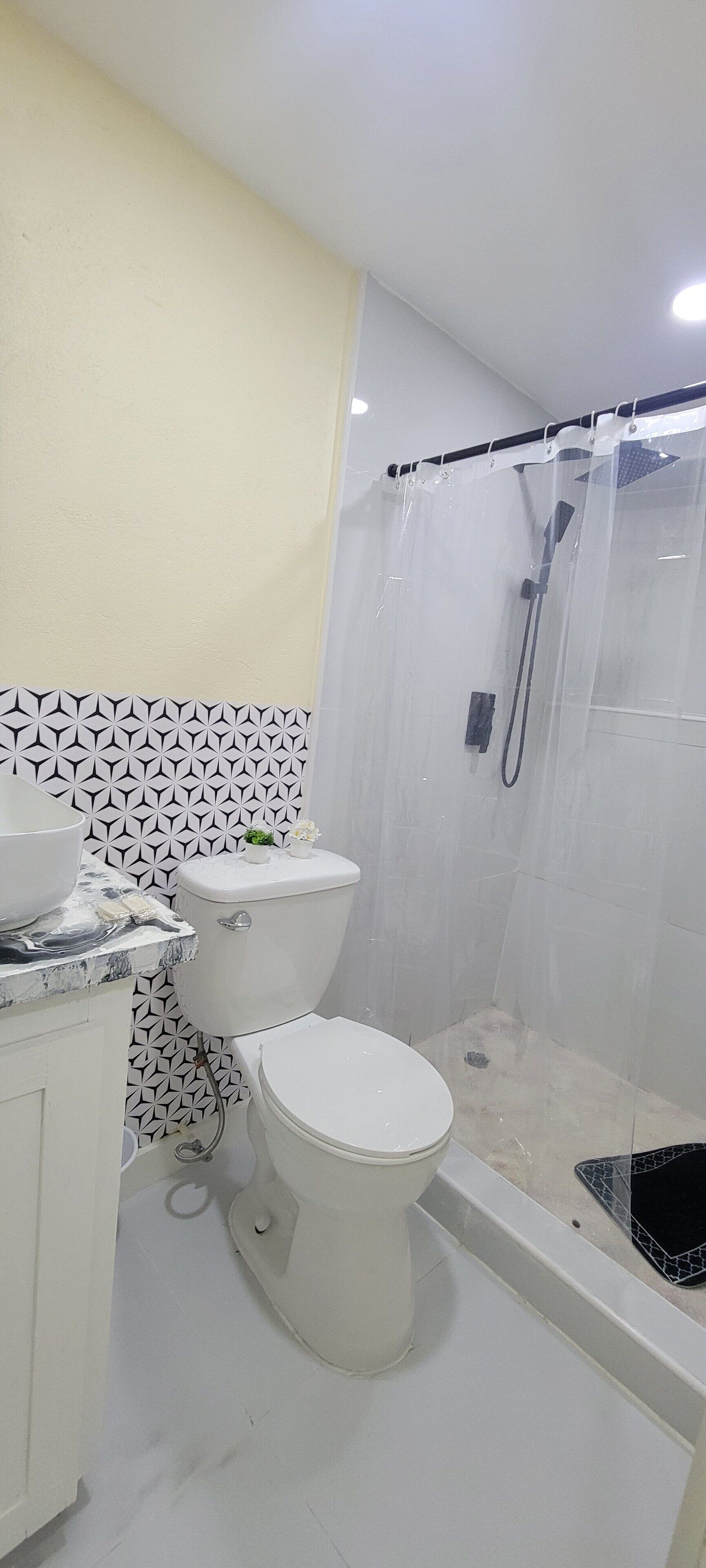 A bathroom with a toilet, a sink, and a shower enclosure.