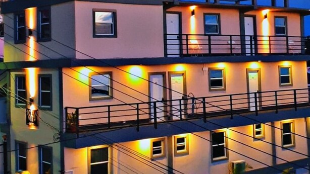 A multi-story building with balconies and exterior lighting.