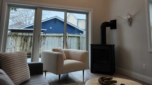 Amplia sala de estar con techo alto, ventanas grandes, chimenea y una zona de estar acogedora.
