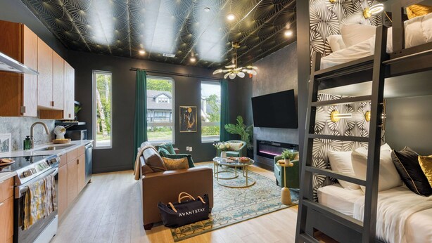 A modern interior with a kitchen, seating area, and a fireplace. - Stylish Studio Near Broadway & East Nashville Restaurants Lischey Loft by Avantstay (Nashville)