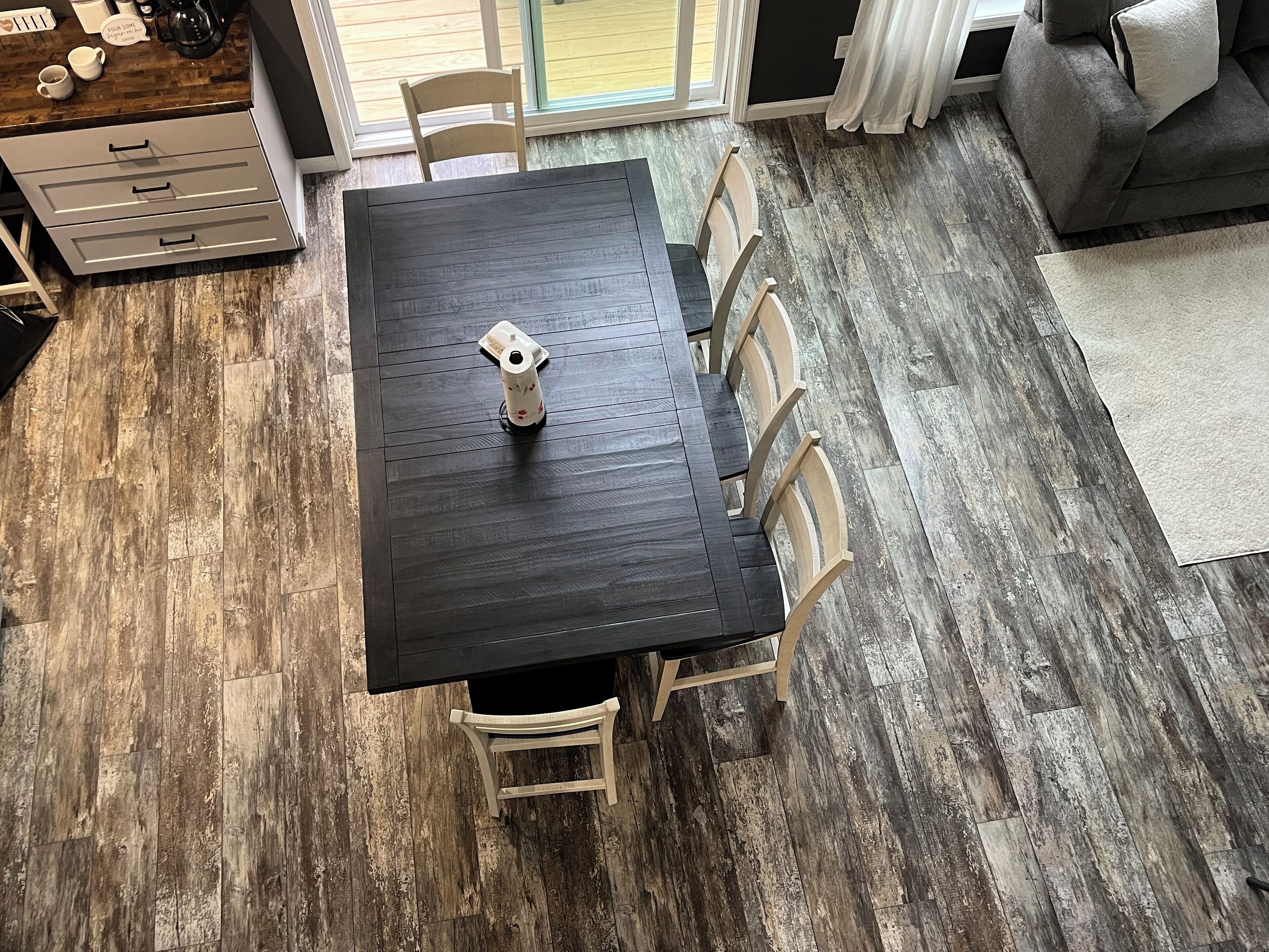 En spiseplads med et mørkt træbord, seks stole og en kaffemaskine.