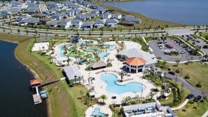 Luchtbeeld van een resort met een centraal gelegen zwembad, een kiosk en een pier.