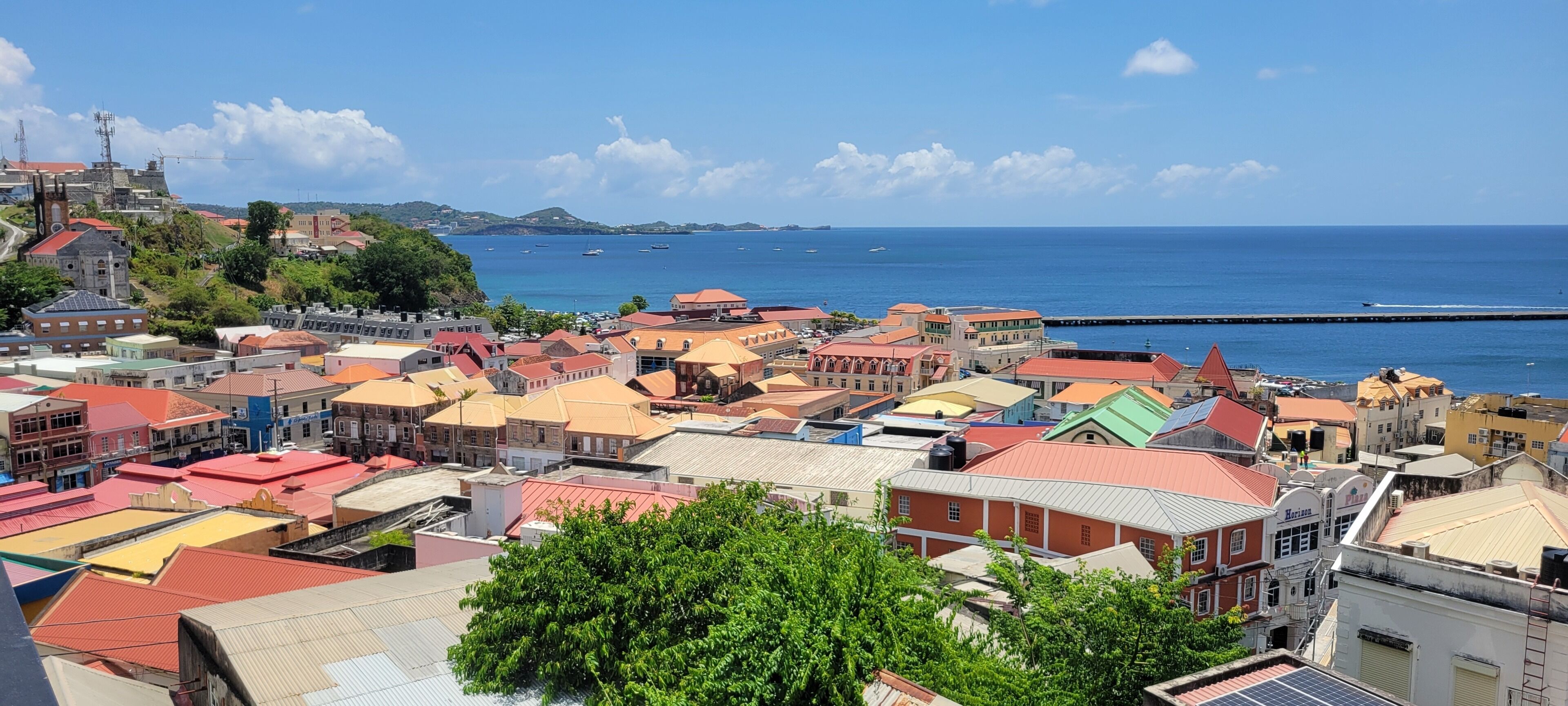A coastal town with colorful buildings, a clear blue sky, and boats in the water.