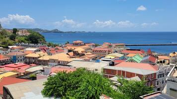 A coastal town with colorful buildings, a clear blue sky, and boats in the water.