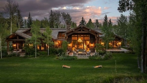 A log cabin with a large porch, multiple windows, and a well-maintained lawn. - Abode at Teton Game, sweeping estate with 3 cabins (Wilson)