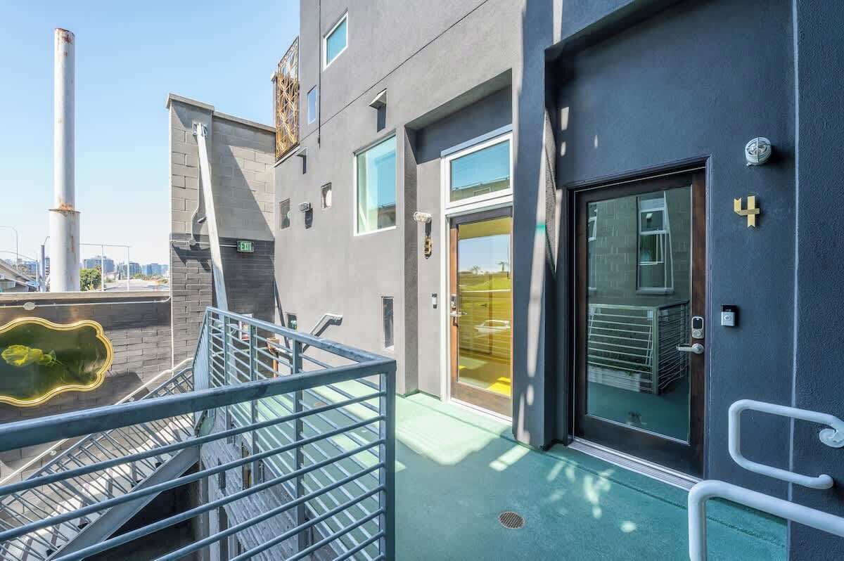 Ein modernes Gebäude mit Glastür, Metalltreppe und Blick auf die Stadtlandschaft.