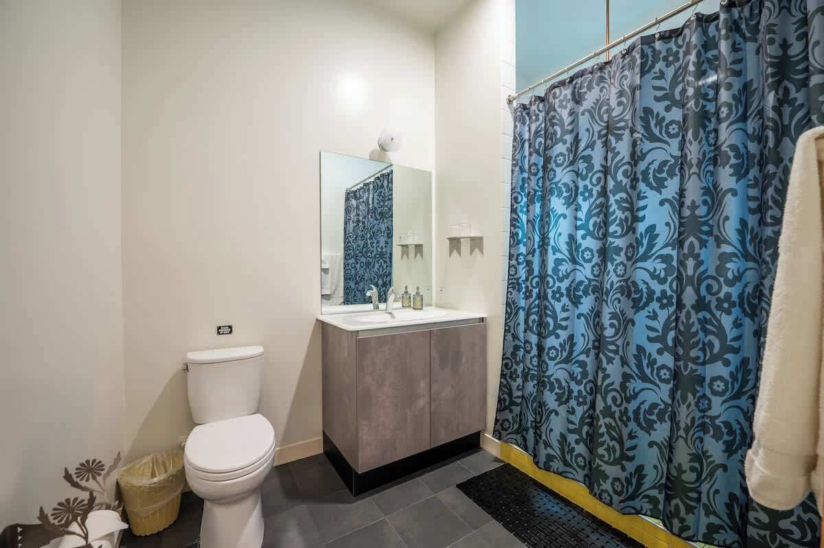 Une salle de bain avec des toilettes, un lavabo et un rideau de douche.