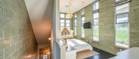 Een moderne badkamer met een groot raam, een badkuip en een wastafel met spiegel.