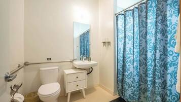 A bathroom with a toilet, sink, and shower curtain.