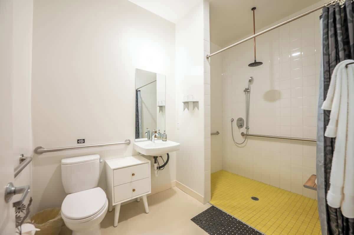 A bathroom with a toilet, sink, and shower.