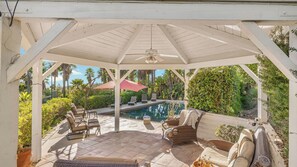 A covered patio with a pool, lounge chairs, and a ceiling fan. - The Tennis Ranch by Avantstay Resort-style Estate Pool + Game Room + Tennis Court Near Wineries (Escondido)