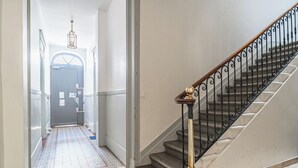 A staircase with a black iron railing and a wooden handrail. - Bright Apartment in the City Centre, Terrace, A/C (Bordeaux)