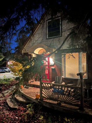 A house with a red door, a wooden porch, and a mailbox.