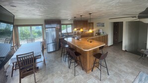 Una cocina amplia con una isla central, armarios de madera y un refrigerador grande.