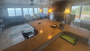 Amplia sala de estar con una isla grande, asientos y vista al mar.