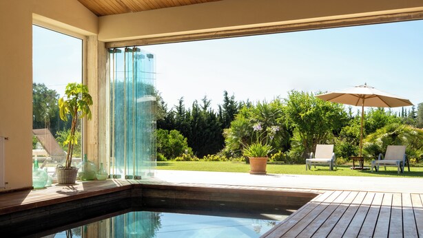 A pool area with a wooden deck, lounge chairs, and potted plants. - Sa Roqueta – Beautiful villa with pool in the heart of Mallorca (Inca)