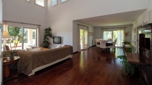 A spacious living area with a large bed, a dining table, and multiple windows. - Sa Roqueta – Beautiful villa with pool in the heart of Mallorca (Inca)