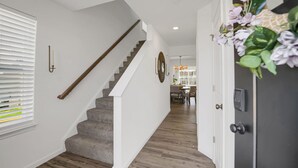 Eine Treppe führt zu einem Essbereich mit einer Chandelüster.