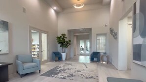Ein geräumiges Wohnzimmer mit einem hellblauen Sofa, einer großen Kübelpflanze und einem modernen abstrakten Gemälde.