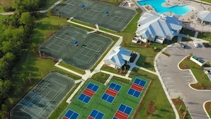 Eine Vogelperspektive eines Golfplatzes mit mehreren Tennisplätzen, einem Schwimmbecken und einem Parkplatz.