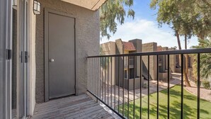 A balcony with a view of a courtyard, a door, and a railing. - Pool -Gym- Great for Mid/Long Stays (Mesa)