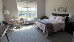 A bedroom with a bed, a desk, a chair, a window, and a radiator. - 410 Modern Brand New Studio Apartment (Old Bridge)