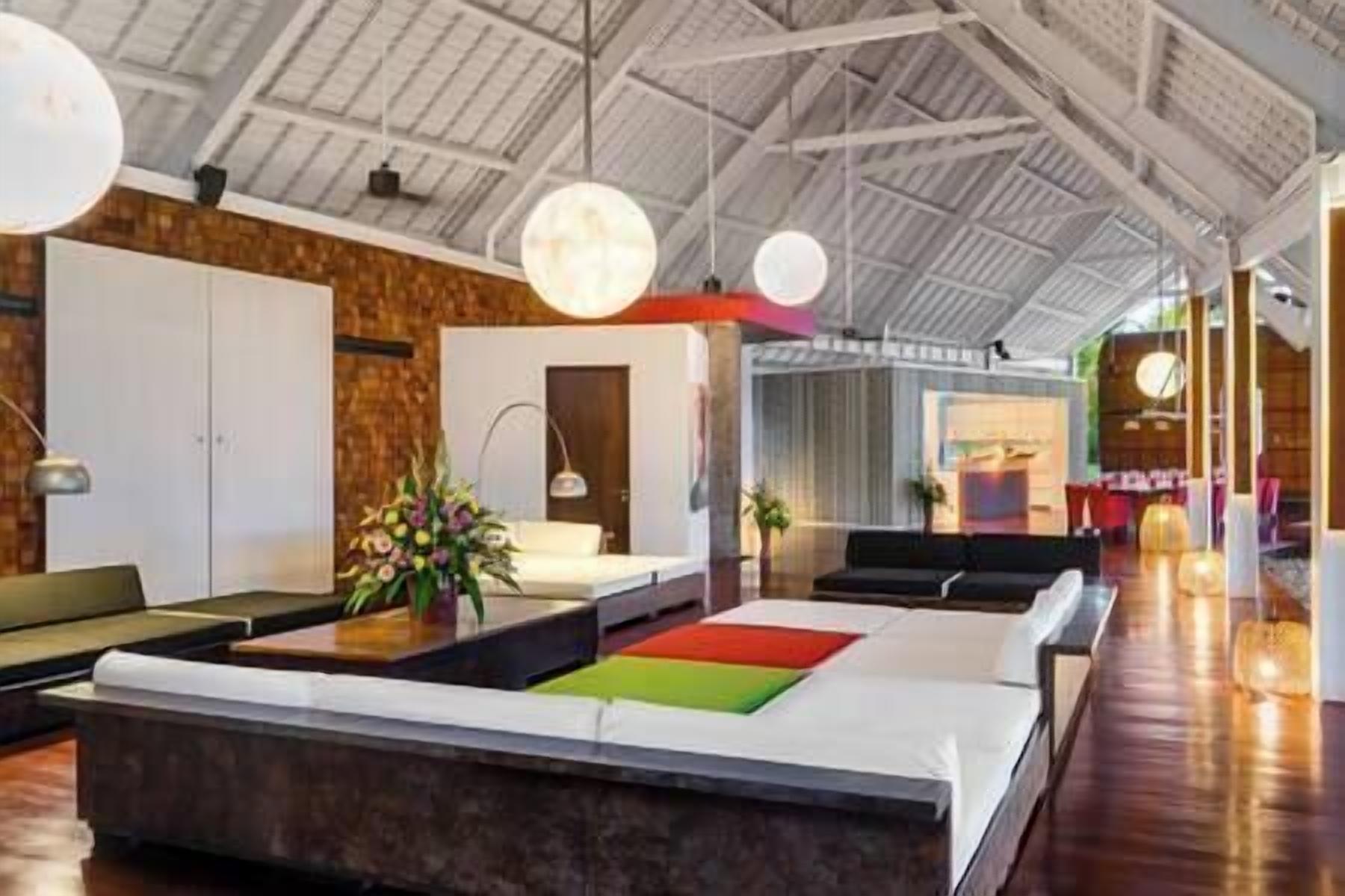 A spacious lobby with a high ceiling, a reception desk, and seating areas.